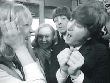 John Lennon in A Hard Day's Night: Paul McCartney attempts to pull John Lennon out the a train car, as Patti Boyd screams in delight.